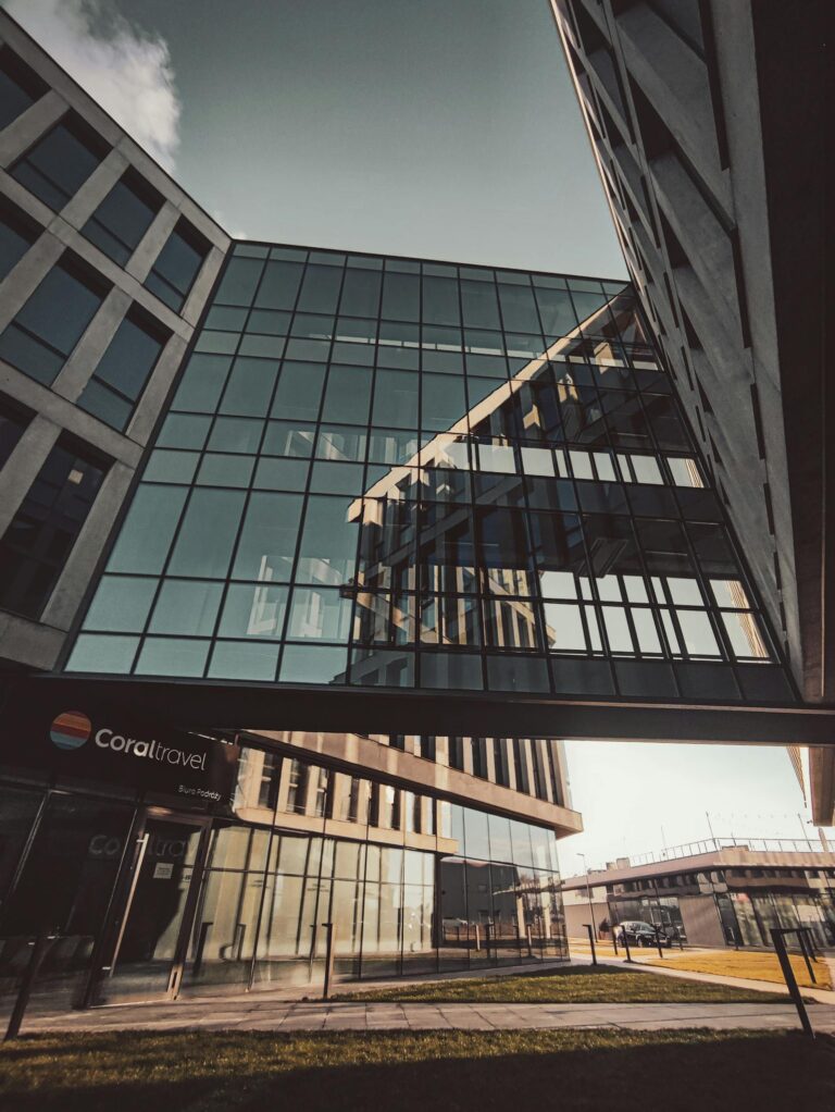 Urban view of a contemporary office building with reflective glass windows and unique architecture.